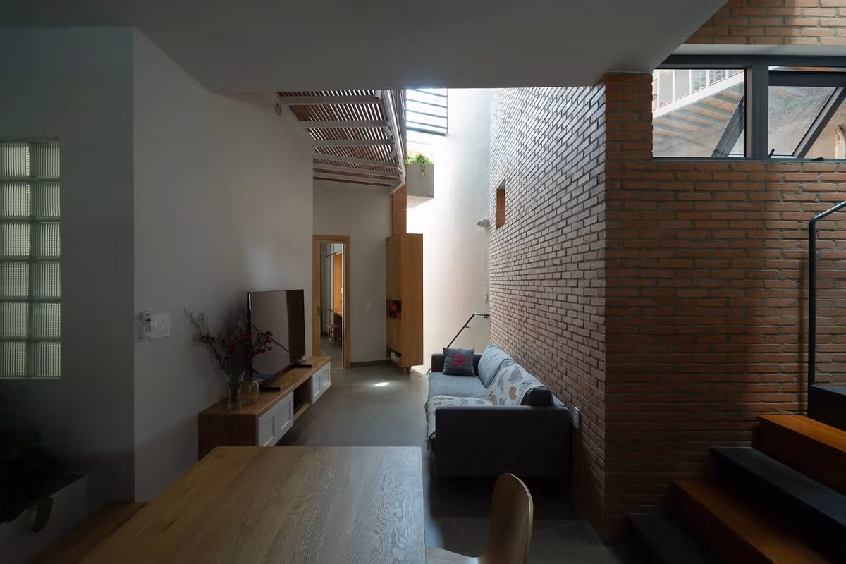 Phòng khách với ánh sáng tự nhiên được lấy tối đa từ giếng trời. Ảnh: Quang Dam/G+architects