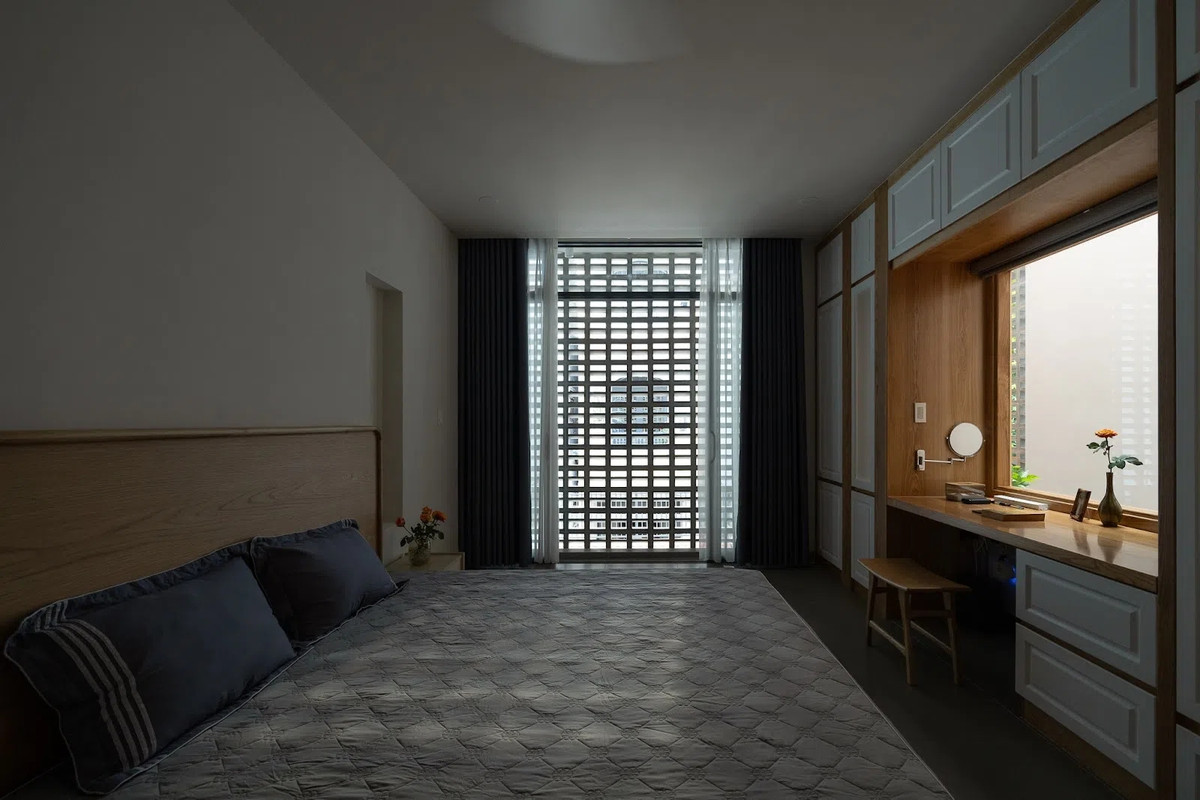 Phòng ngủ lấy sáng từ 2 mặt, cửa kính khiến bàn làm việc luôn đủ ánh sáng tự nhiên mà không cần hệ thống đèn cầu kỳ. Ảnh: Quang Dam/G+architects
