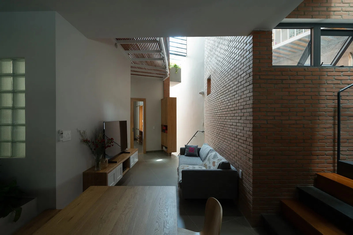 Phòng khách với ánh sáng tự nhiên được lấy tối đa từ giếng trời. Ảnh: Quang Dam/G+architects