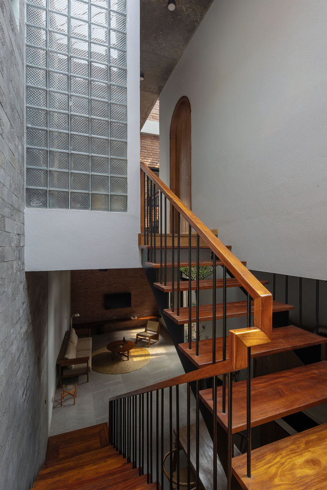 Tầng 2 được thiết kế với 2 phòng ngủ cơ bản, và một cầu thang sắt kết nối lên mái nhà thông qua giếng trời ở giữa nhà. Ảnh: Hoàng Lê