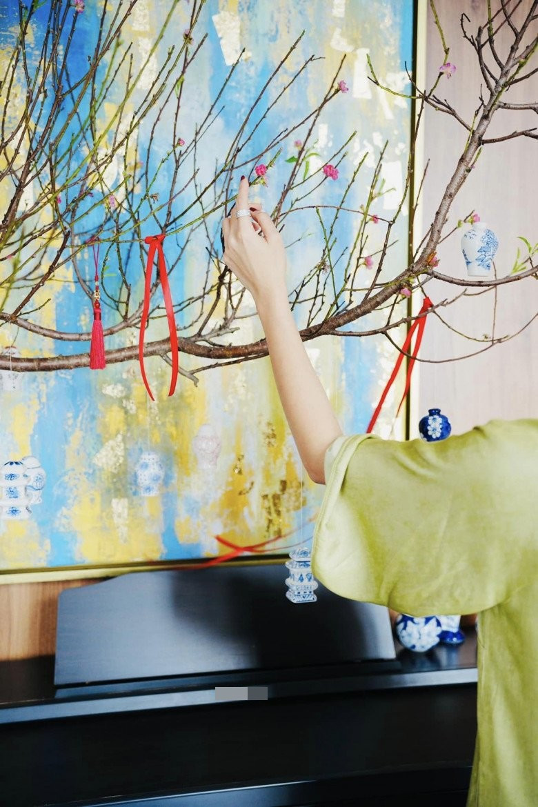 Cả hai cùng nhau tháo cắt treo từng chiếc chuông nhỏ trên cành đào.