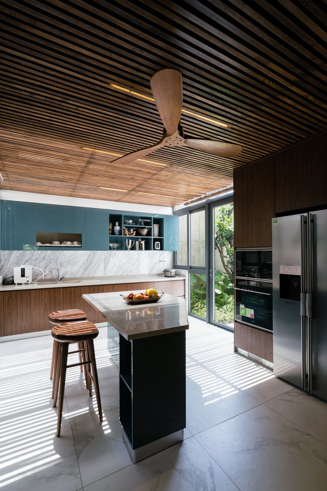 Khu vực ăn uống và bếp có tầm nhìn thẳng ra khu vườn. Bộ bàn ăn phù hợp với việc sử dụng gỗ cho trần và sàn.