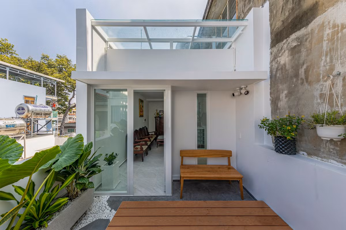 Tầng 3 là khu vực bàn thờ nhìn ra sân chơi, kết hợp với mảng xanh tạo không gian trong lành. Nguồn ảnh: Paul Phan