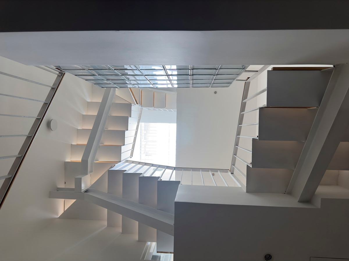 Ánh sáng còn được phản chiếu qua lan can gạch kính và cửa kính trượt.