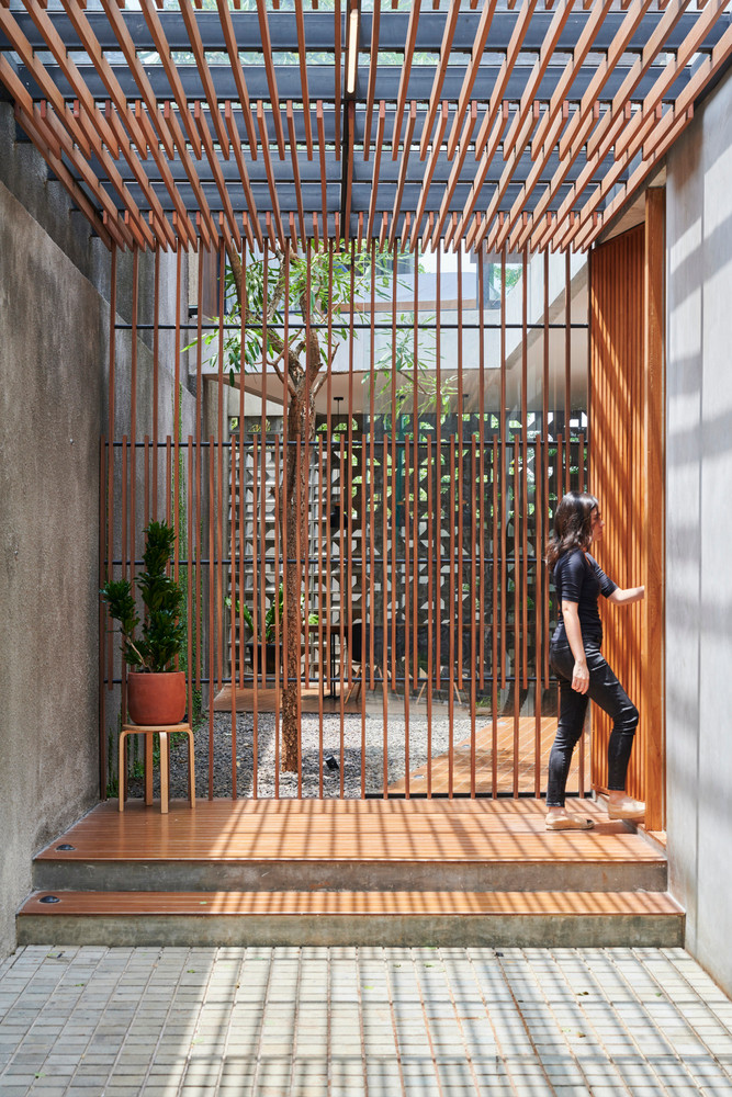 Vách ngăn và giàn mái gỗ vừa giúp lọc nắng vừa mang đến vẻ đẹp mộc mạc cho căn nhà.