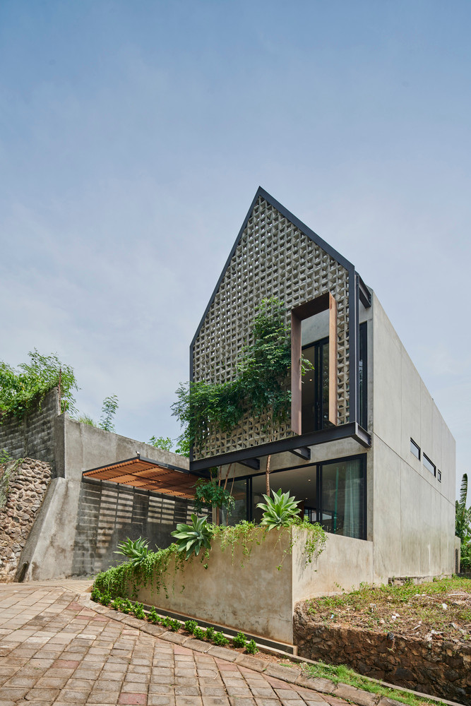  Ngôi nhà nằm ở rìa xa nhất của một khu dân cư trên vùng đồi núi Semarang (Indonesia). Khu vực này được bao quanh bởi những bức tường chắn cao đóng vai trò là ranh giới của khu vực lân cận ở hai bên cùng với thảm thực vật hoang dã phía sau.