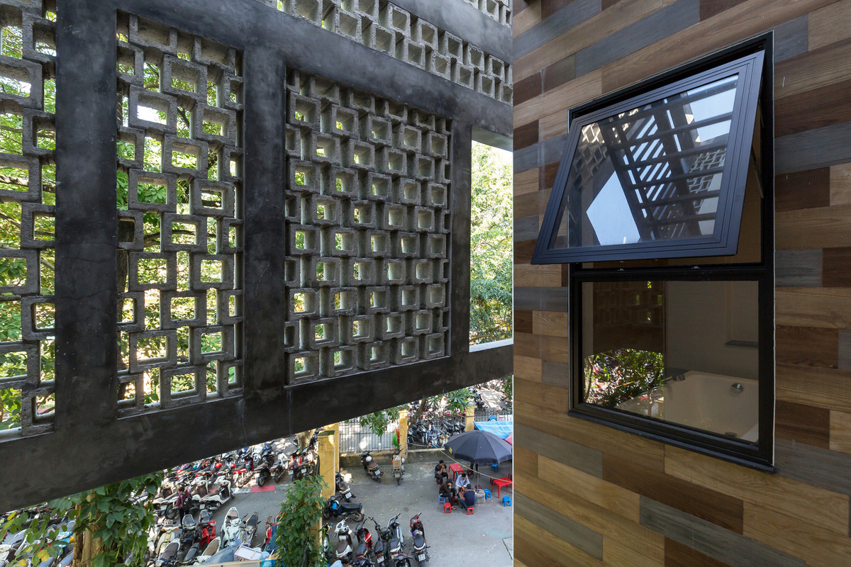 Với những tấm kính lớn và gạch thô, rỗng, toàn cảnh trước nhà với cây lâu năm cao gần 20m được tối ưu hóa để có sự hài hòa về màu sắc từ lá cây (xanh) và bê tông (xám).