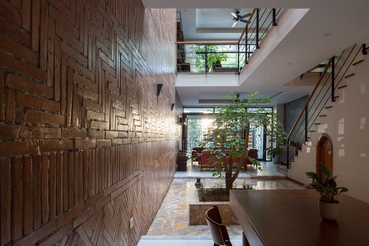 Xen kẽ giữa các đường dọc và ngang là một bồn cây lớn ở góc loggia trên tầng 2, mang lại sự cân bằng và tạo sự khác biệt cho mặt tiền của nhà phố.