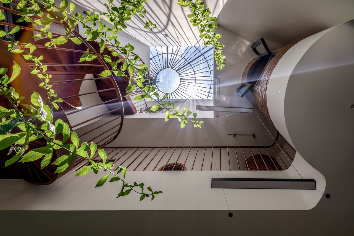 Luồng khí tự nhiên lưu thông qua các khoảng hở, đi vào lõi giếng trời trung tâm của căn nhà và sau đó thoát ra qua các lỗ gạch đục lỗ, tạo chu trình thông gió tự nhiên. Ảnh: Minq Bui