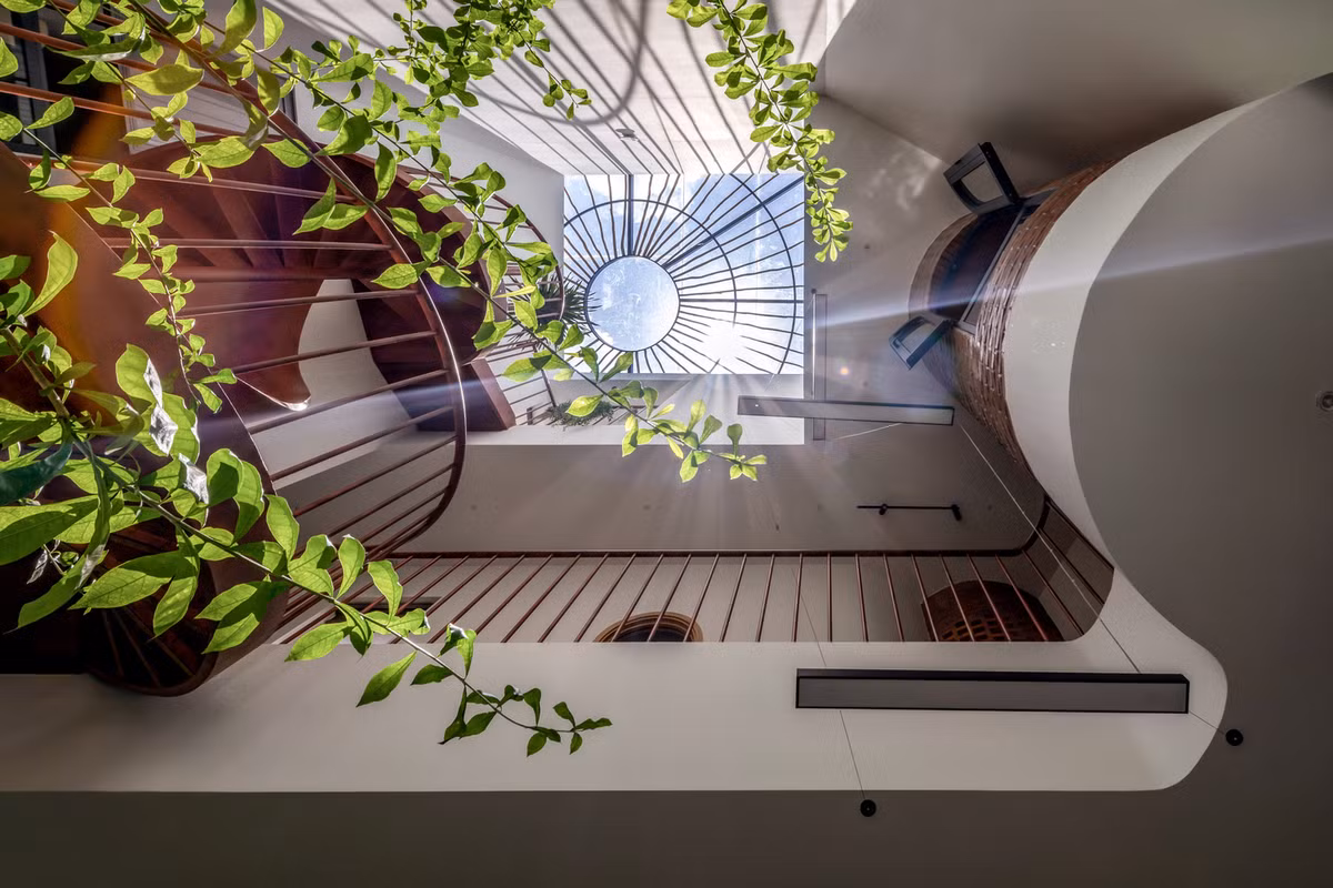 Luồng khí tự nhiên lưu thông qua các khoảng hở, đi vào lõi giếng trời trung tâm của căn nhà và sau đó thoát ra qua các lỗ gạch đục lỗ, tạo chu trình thông gió tự nhiên. Ảnh: Minq Bui