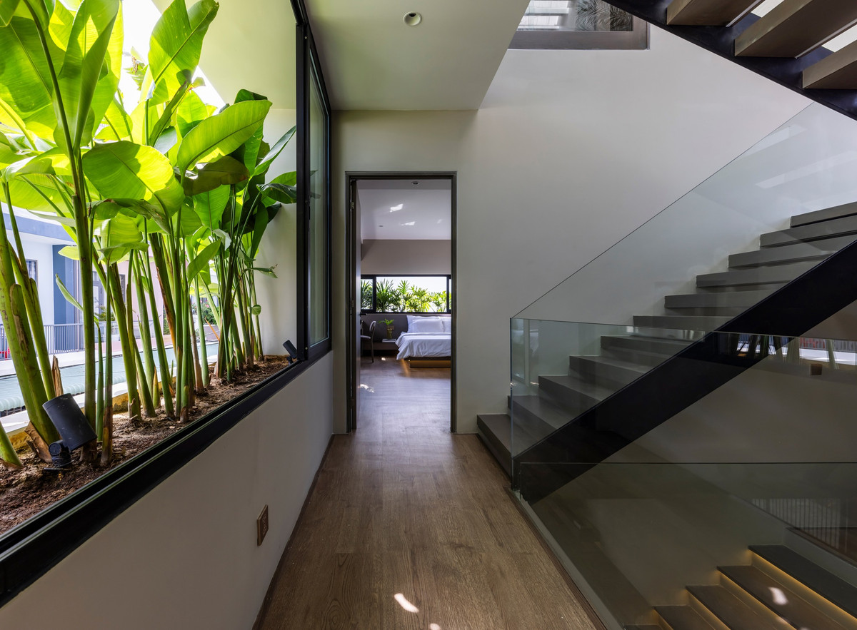 Tầng cao nhất là điểm nhấn trong nhà. Những vách kính cỡ lớn giúp không gian bên trong phòng và bên ngoài vườn hòa quyện một cách tự nhiên.