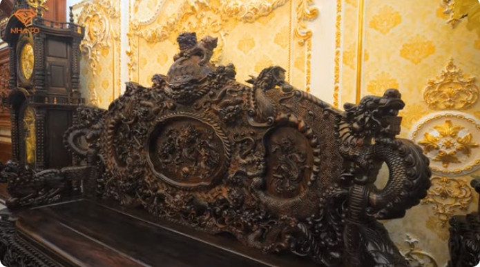 Điểm đặc biệt của bộ bàn ghế này là bên dưới có thêm long sàng nhằm tăng tính hoành tráng. Bộ này có giá vào khoảng 1 tỷ đồng, được đặt làm thủ công toàn bộ tại làng nghề gỗ Đồng Kỵ và mất khoảng 6 tháng để hoàn thành.