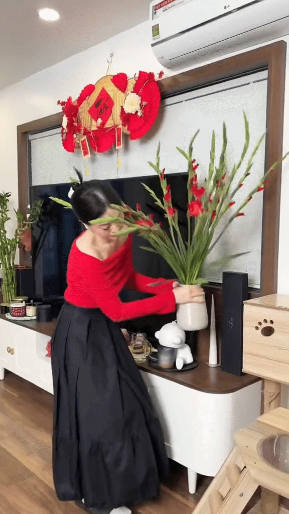 Phương Nga đặt một bình dơn đỏ chưng trên kệ TV ở phòng khách.