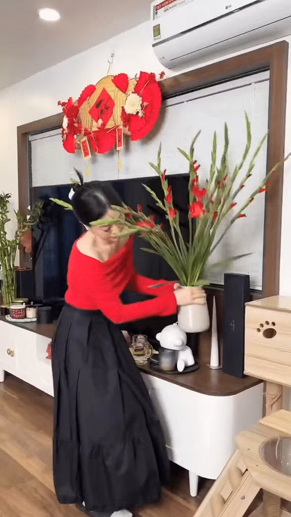 Phương Nga đặt một bình dơn đỏ chưng trên kệ TV ở phòng khách.