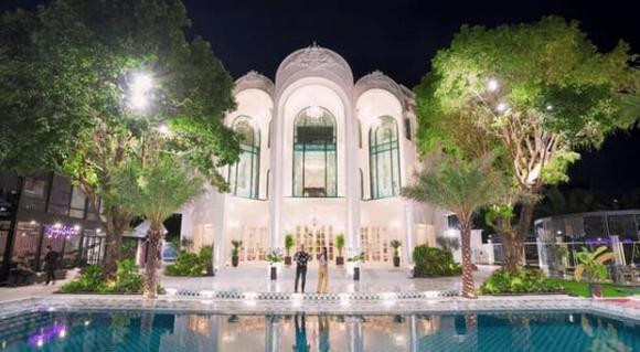 Bên ngoài biệt thự có tông màu trắng chủ đạo, trồng nhiều cây xanh.