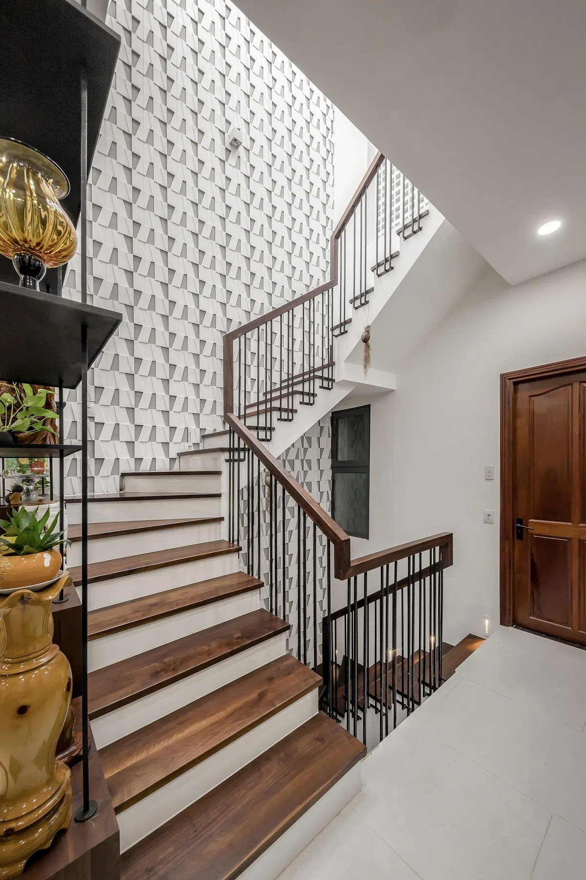 Giếng trời được tạo điểm nhấn bằng bức tường gạch 3D ghép có tác dụng tiêu âm, giảm tiếng ồn.