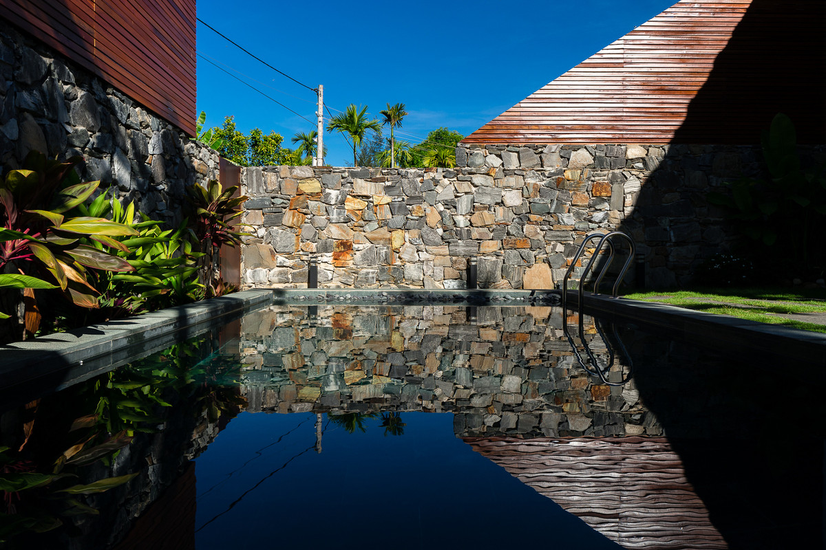 Hàng rào bao xung quanh biệt thự song lập là những mảng đá được sắp đặt tự nhiên.