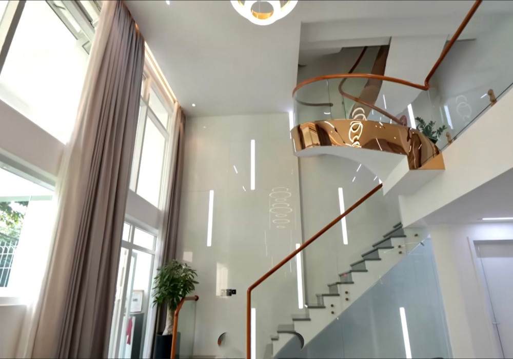 Phòng khách xây theo lối thông tầng, tường được ốp đá sang trọng. Ảnh: chụp màn hình NhaF