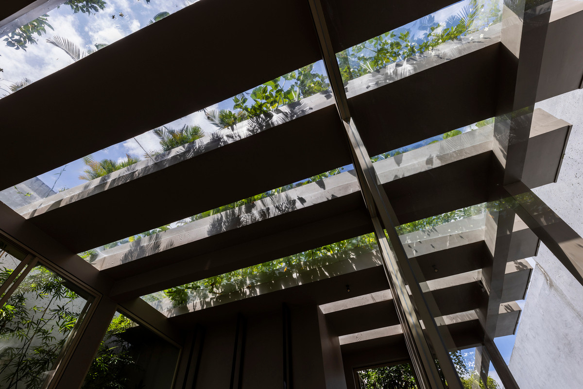 Cây xanh được bố trí khắp không gian. Những khe thông gió và cửa kính lớn giúp tản nhiệt cho căn nhà, không cần sử dụng điều hòa kể cả trong những ngày nắng nóng.