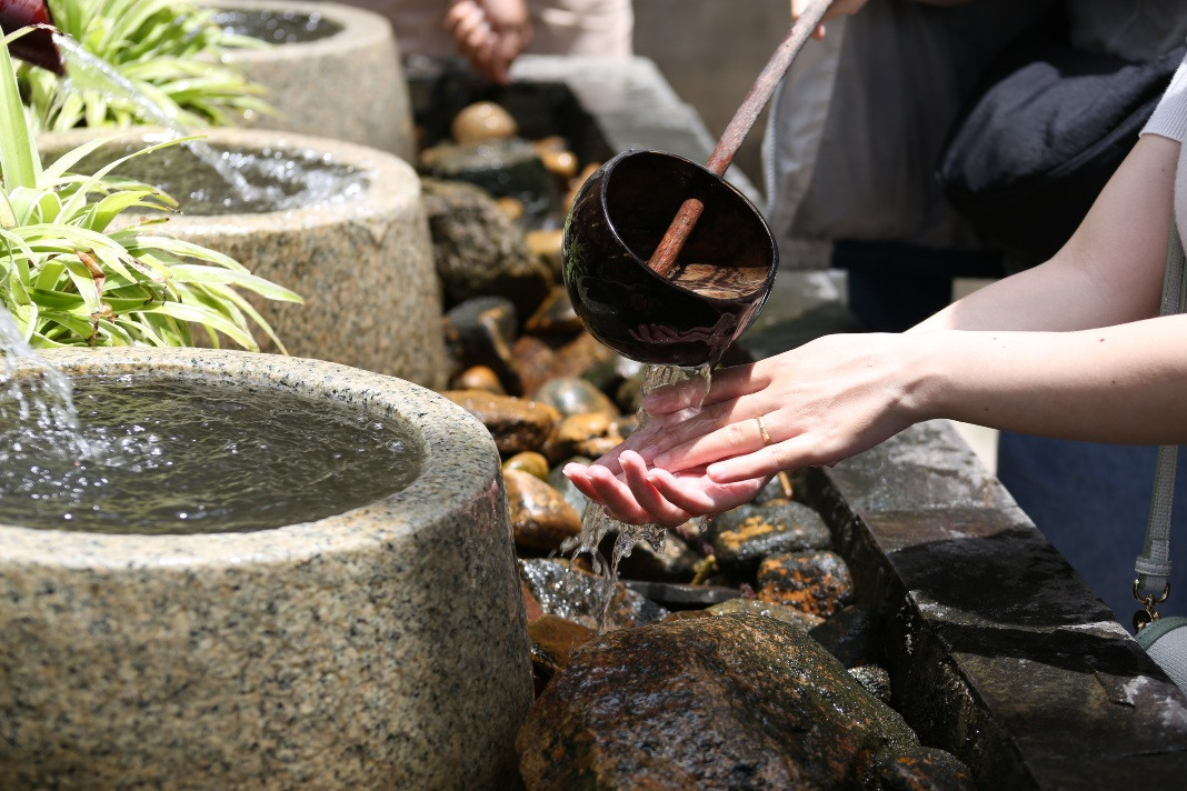 Du khách thực hiện nghi thức rửa tay – tượng trưng cho sự thanh lọc trước khi bước lên các bậc thang vào chùa. Ảnh: Thế Kỳ