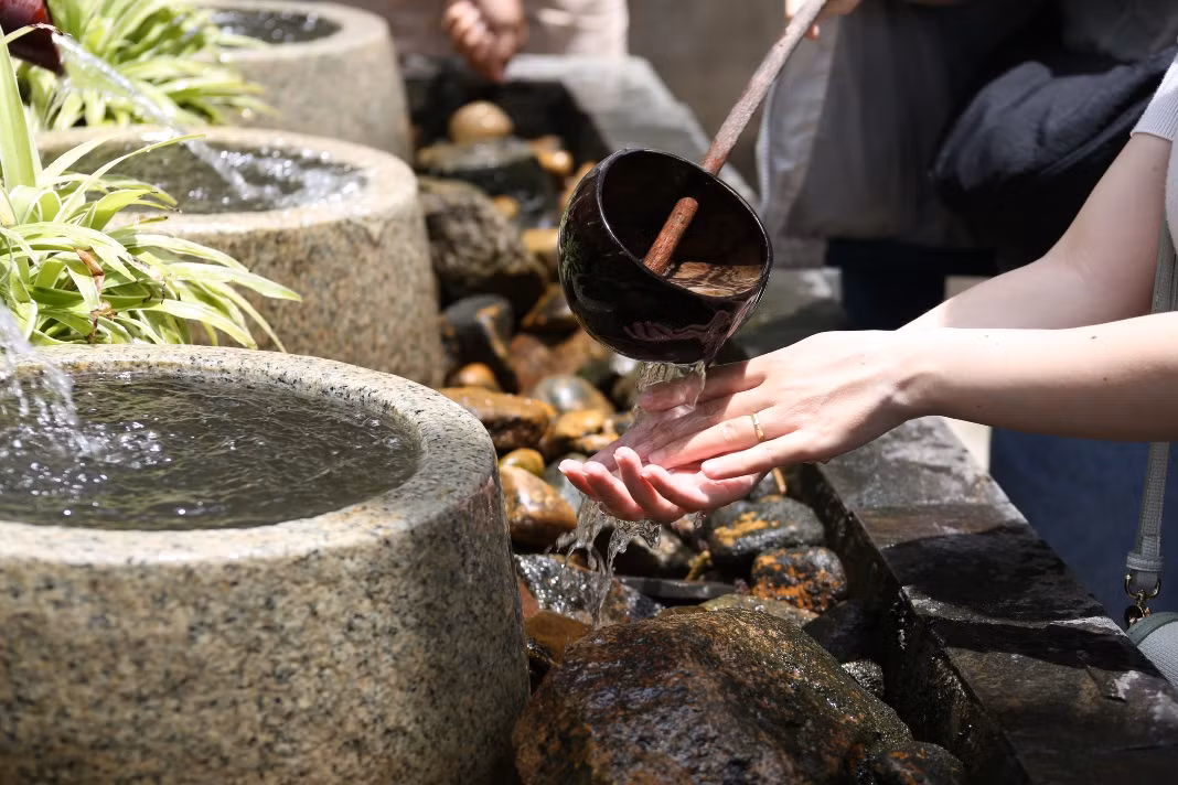 Du khách thực hiện nghi thức rửa tay – tượng trưng cho sự thanh lọc trước khi bước lên các bậc thang vào chùa. Ảnh: Thế Kỳ