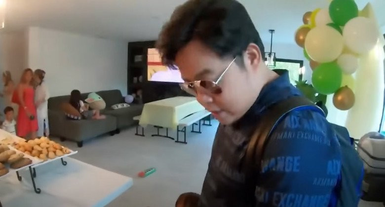 Phòng khách không quá rộng, đặt một bộ sofa màu xám, có chiếc ti vi lớn.