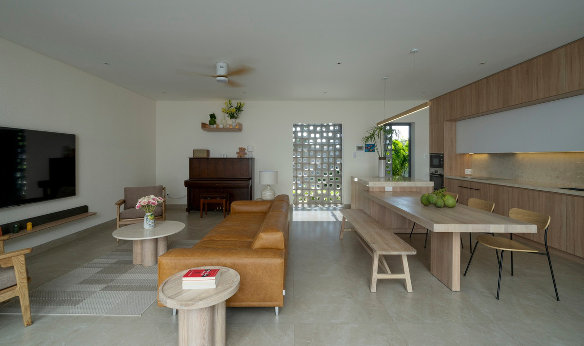 Không gian sinh hoạt chung được che chắn khéo léo bằng bức tường bông gió trước sảnh trải nệm nhằm giảm nhiệt và tạo sự riêng tư.