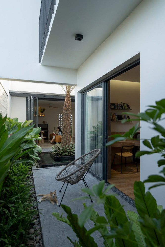 Phía sau là không gian sân vườn và là nơi để gia chủ tập yoga. Điều đặc biệt là sân giữa và sân sau của ngôi nhà được kết nối với nhau, không bị gián đoạn, tạo điều kiện thông thoáng. Sân vườn dường như bao trùm toàn bộ khối ngủ.