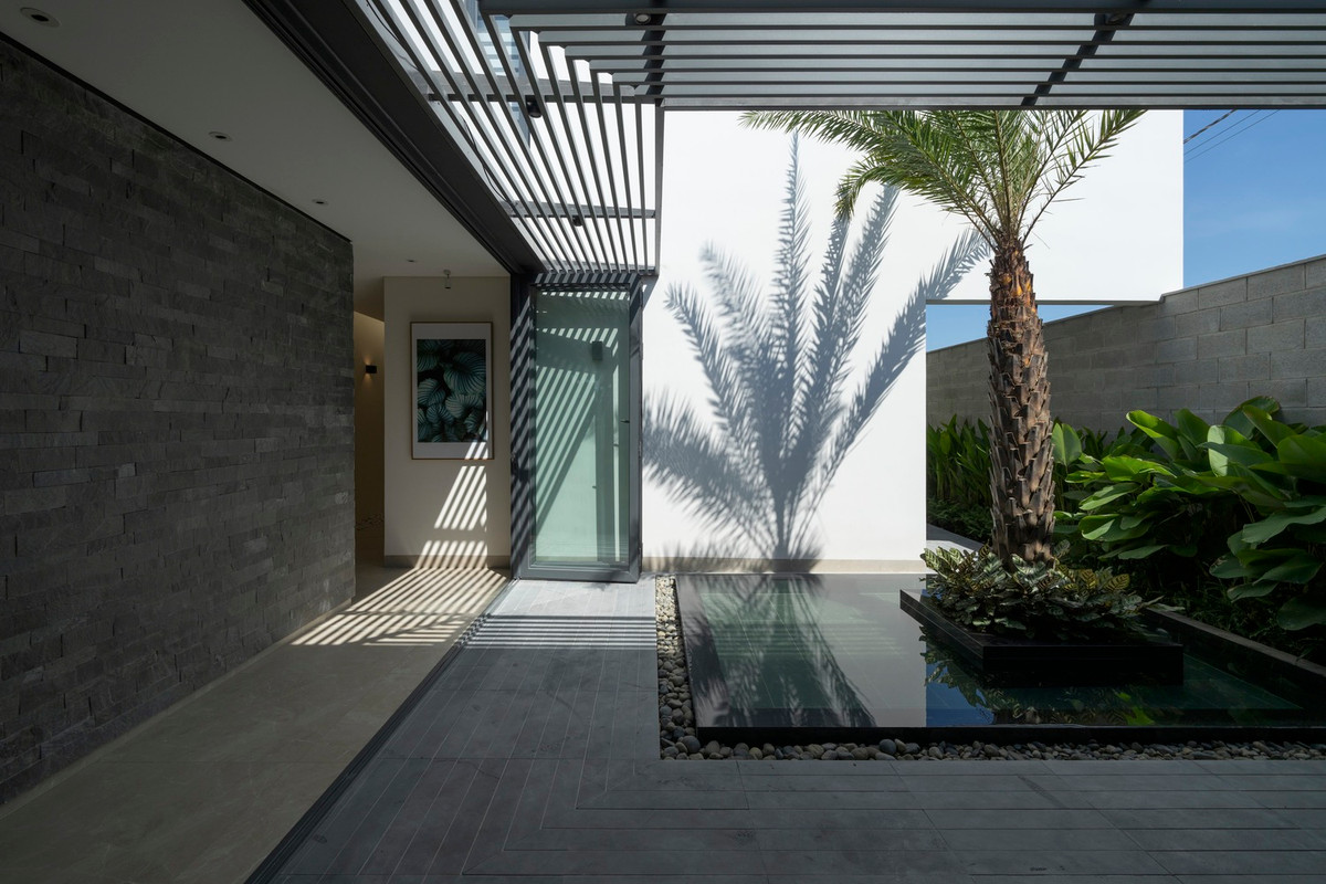 Hồ nước giúp làm dịu không gian phòng khách với tầm nhìn được nối với khoảng sân giữa nhà.