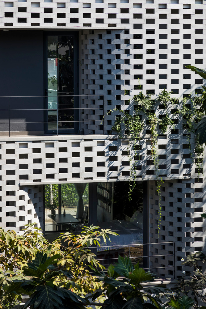 Ngoài lớp tường lỗ ở mặt tiền phía tây và phía đông, căn nhà còn có thêm các bức tường bê tông để tăng sự riêng tư cho gia đình.