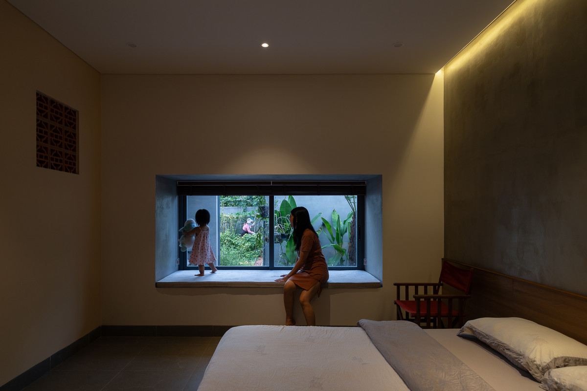 Phòng ngủ của cha mẹ có ô cửa sổ nối thẳng ra sân vườn xanh mát. Ảnh: Quang Trần