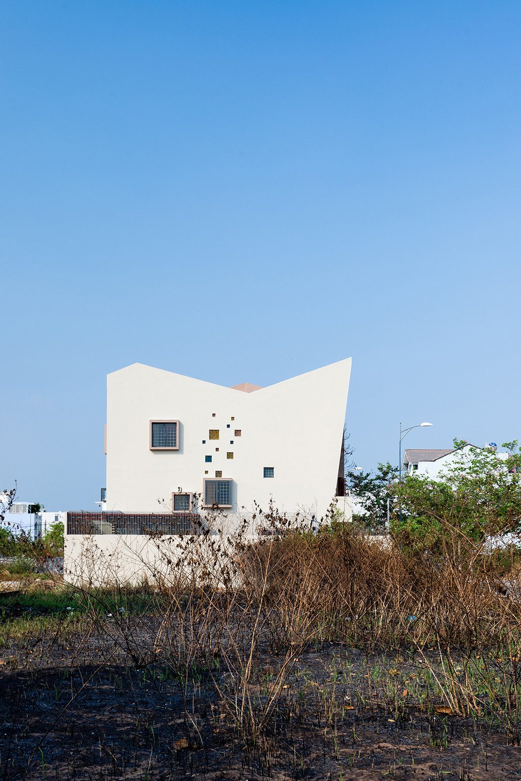 Xuất phát từ mong muốn của gia chủ về một căn nhà có mái ngói dốc truyền thống, nhiều ánh sáng và khoảng xanh... đội ngũ kiễn trúc sư đã kiến tạo một công trình lấy cảm hứng từ hình khối điêu khắc với đường nét kiến trúc đơn giản, sắc nét.