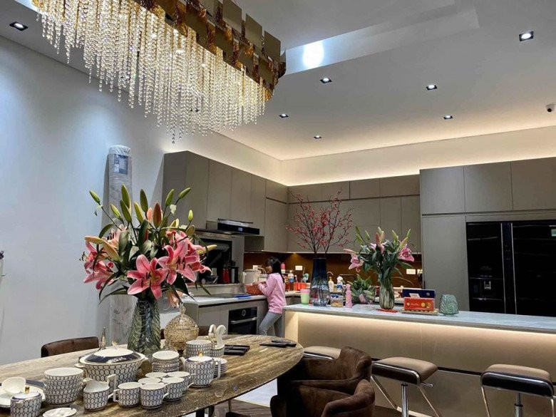 Bếp và phòng ăn rộng rãi, được trang trí lung linh với đèn chùm và hoa tươi.