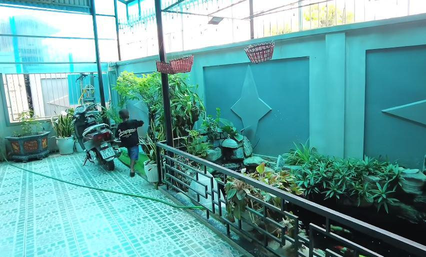 Phía trước nhà là khoảng sân rộng rãi, lát gạch hoa từ cổng đến bậc tam cấp.