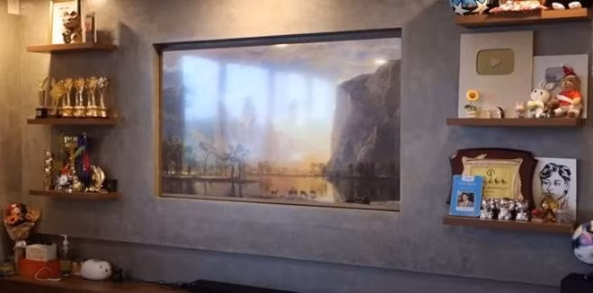 Không gian phòng khách đơn giản, trưng bày những món lưu niệm, giải thưởng, đồ sưu tầm khi nam ca sĩ đi nước ngoài...