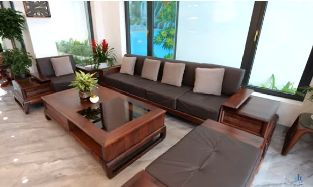 Giữa phòng khách là sofa hình chữ U kích thước lớn bằng gỗ óc chó.