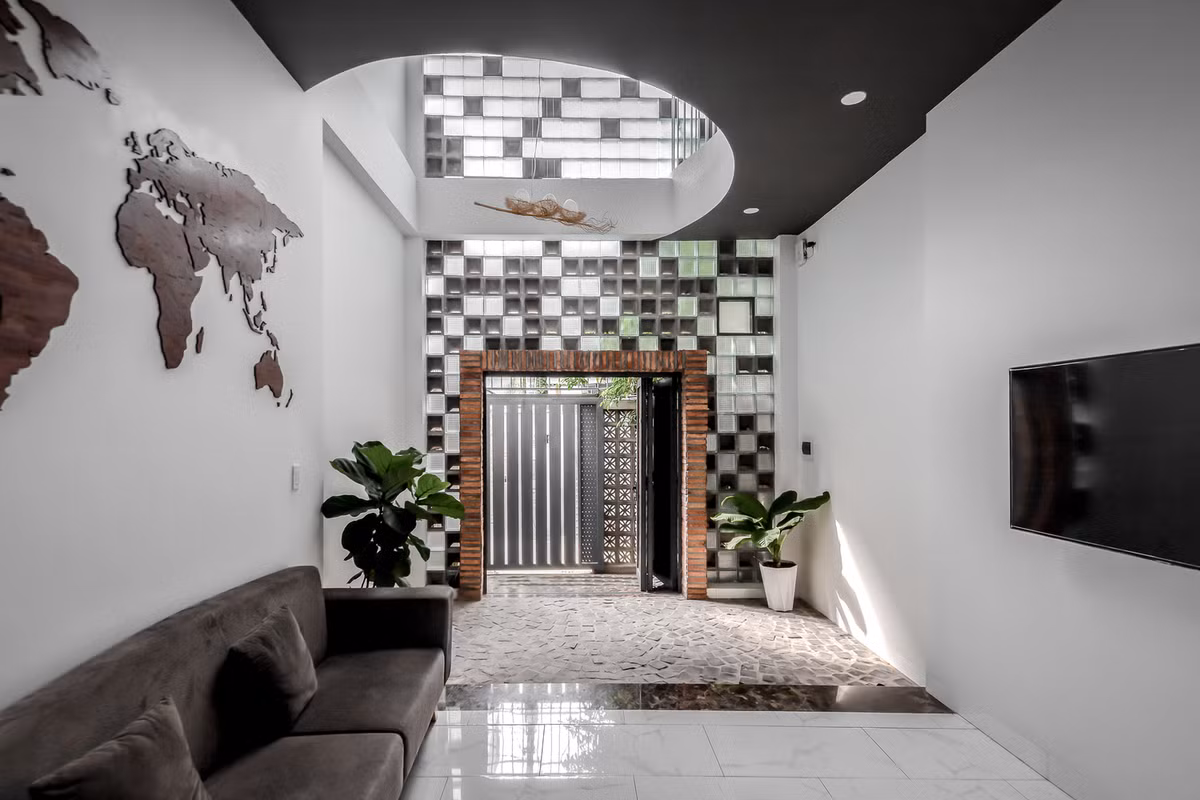 Kiến trúc sư sử dụng nguyên lý chênh lệch áp suất nhằm tạo ra luồng khí tự vận hành trong không gian. Theo đó, gạch bông gió được đặt ở vị trí thấp (càng thấp áp suất càng lớn) kết hợp với hai giếng trời giữa và sau nhà ở trên mái (càng cao áp suất càng nhỏ) tạo ra sự chênh lệch áp suất. Ảnh: Minq Bui