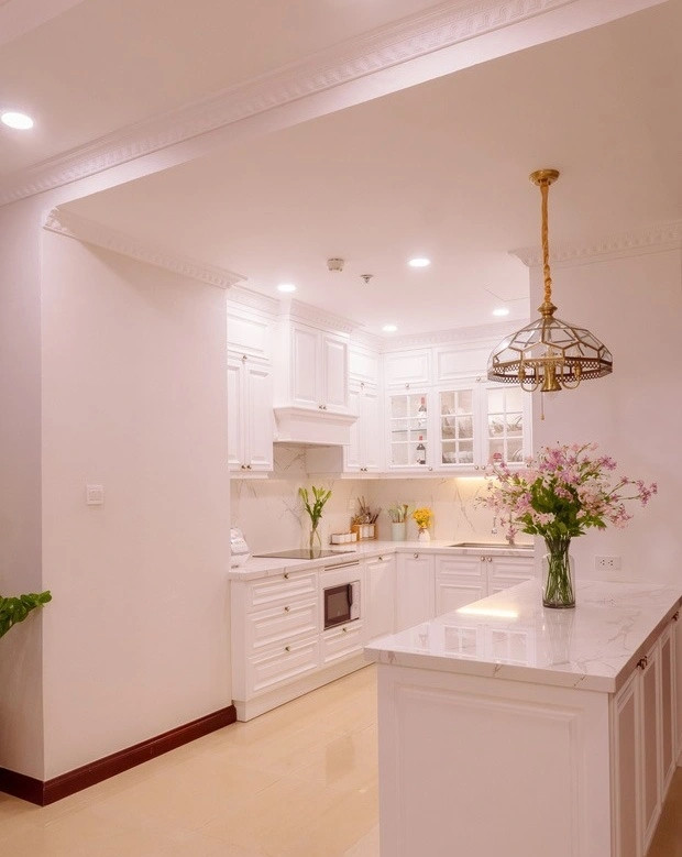 Góc bếp được tô điểm bởi nhiều bình hoa tươi.