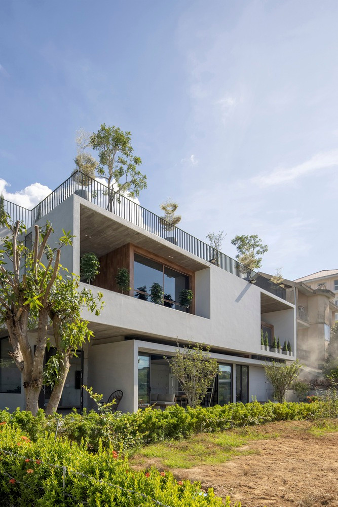 PVT House tọa lạc trong một khu dân cư yên tĩnh ở Phường Vỹ Dạ, Thành phố Huế. Ngôi nhà nằm cạnh khu vườn tươi tốt, mang đến tầm nhìn mở rộng, ánh sáng tự nhiên dồi dào và bầu không khí trong lành, yên tĩnh. Ảnh: Hoàng Lê