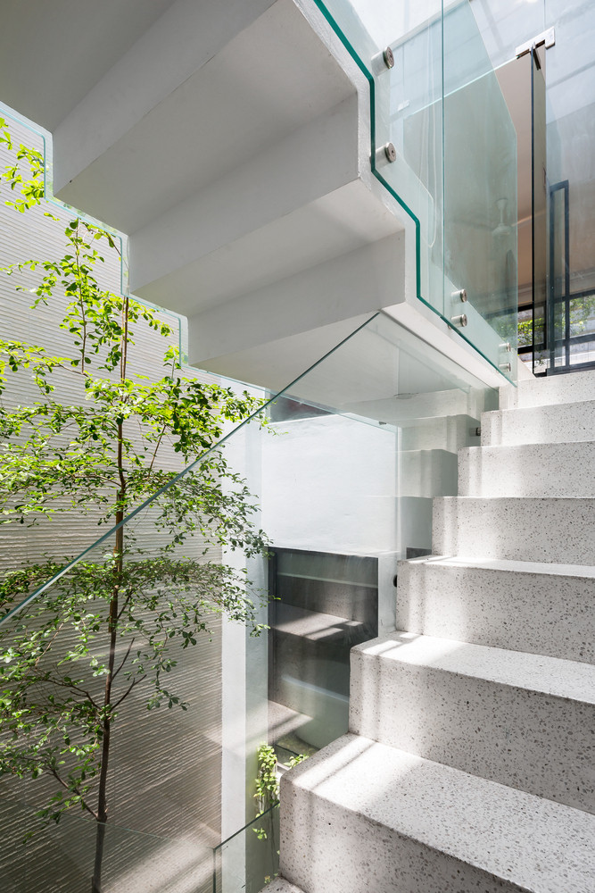 Khoảng trống ở giữa nhà với mái kính lớn giúp di chuyển trên cầu thang thoải mái, rộng rãi và không ngột ngạt như nhà ống thông thường.