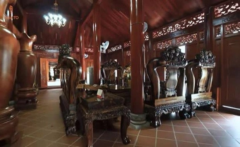 Tại gian chính của ngôi nhà, gia chủ bày bộ bàn ghế "khổng lồ" làm từ gỗ cẩm Việt - một loại gỗ giá trị cao, có hương thơm đặc trưng, vân đẹp. Ảnh chụp màn hình NhaTo