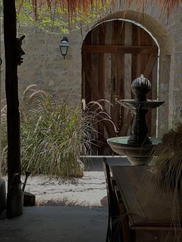 Tổng thể căn nhà mang phong cách mộc mạc, thậm chí có phần gai góc xù xì với cổng làm bằng gỗ mộc.