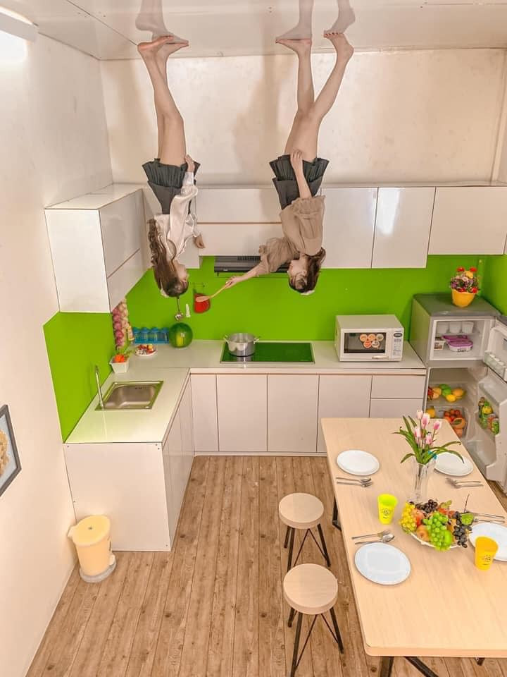 Phòng bếp nổi bật với miếng dàn tường màu xanh lục trên nền trắng.