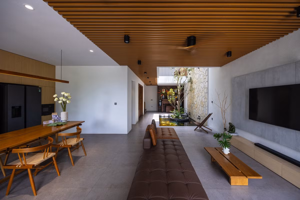 Nhờ tận dụng tối đa các điểm nhìn ra khu vườn phía trước và giếng trời giữa nhà, các mảng xanh và không gian sử dụng được hòa vào nhau, không còn sự ngăn chia giữa trong và ngoài. Ảnh: Triệu Chiến