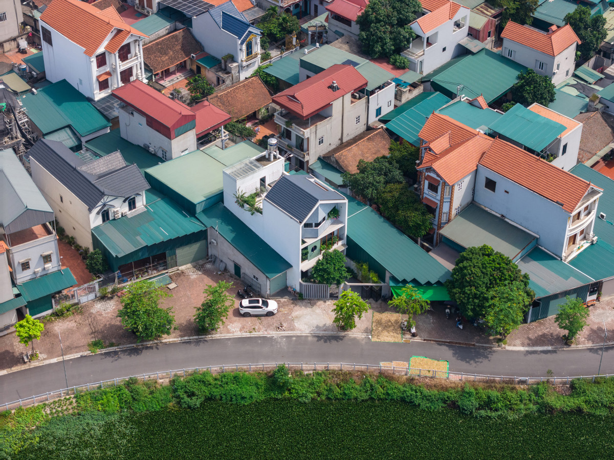 Gia chủ mong muốn tạo ra một không gian sống gắn kết 3 thế hệ trong gia đình, gần gũi với môi trường tự nhiên. Khu đất xây nhà không vuông vắn do con đường ven sông cắt qua, các mặt bên và phía sau tiếp giáp công trình đã xây dựng. Ảnh: Triệu Chiến