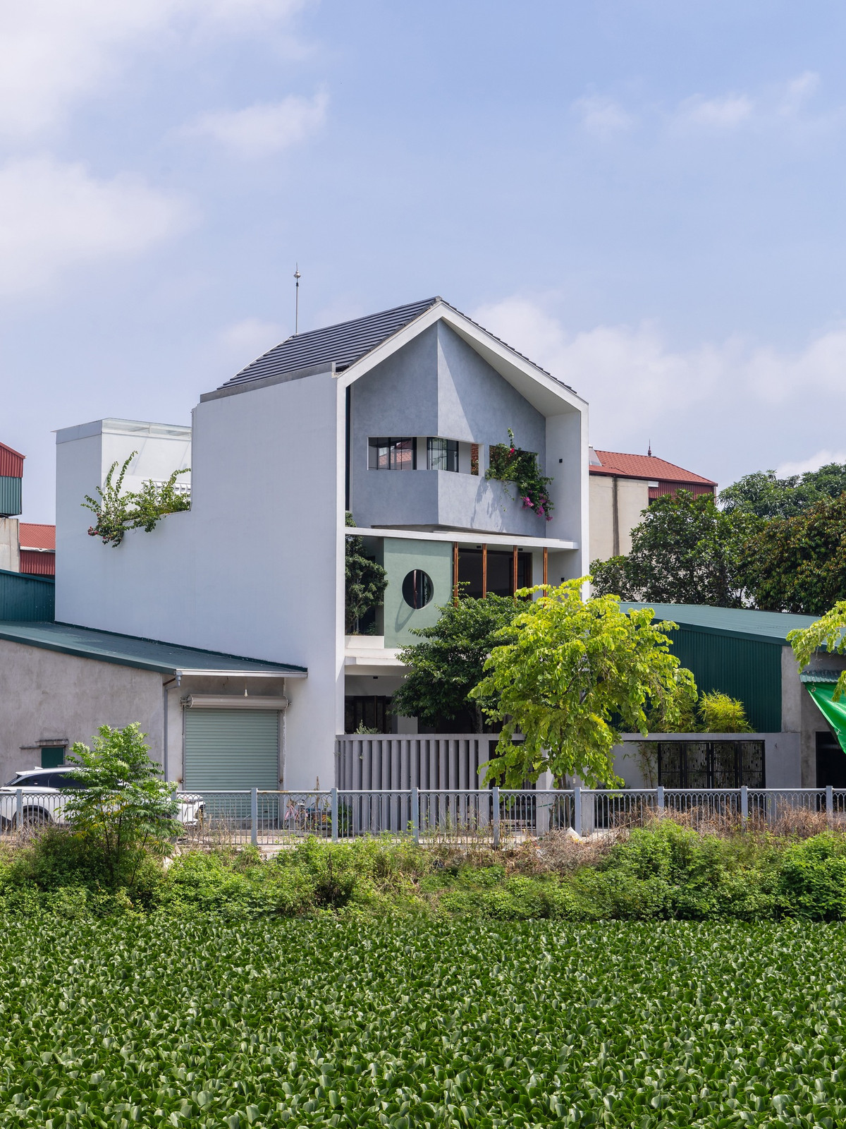 Mặt tiền của ngôi nhà được lấy cảm hứng từ những đường cắt vát trên bề mặt một viên ngọc. Đây là giải pháp giúp đường chéo của khu đất ăn nhập với tổng thể, tạo ra bức tranh về sự thay đổi của ánh sáng vào các thời điểm khác nhau. Ảnh: Triệu Chiến