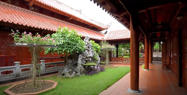 Phía sau nhà chính là dãy nhà ngang dùng làm phòng ăn và nhà bếp, nối với nhau bằng hành lang lát gạch đỏ sạch sẽ. Ảnh chụp màn hình NhaTo