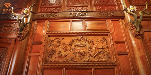 Trên tường là nhiều bức tranh gỗ cùng với các chi tiết được chạm khắc công phu, tỉ mỉ. Ảnh chụp màn hình NhaTo