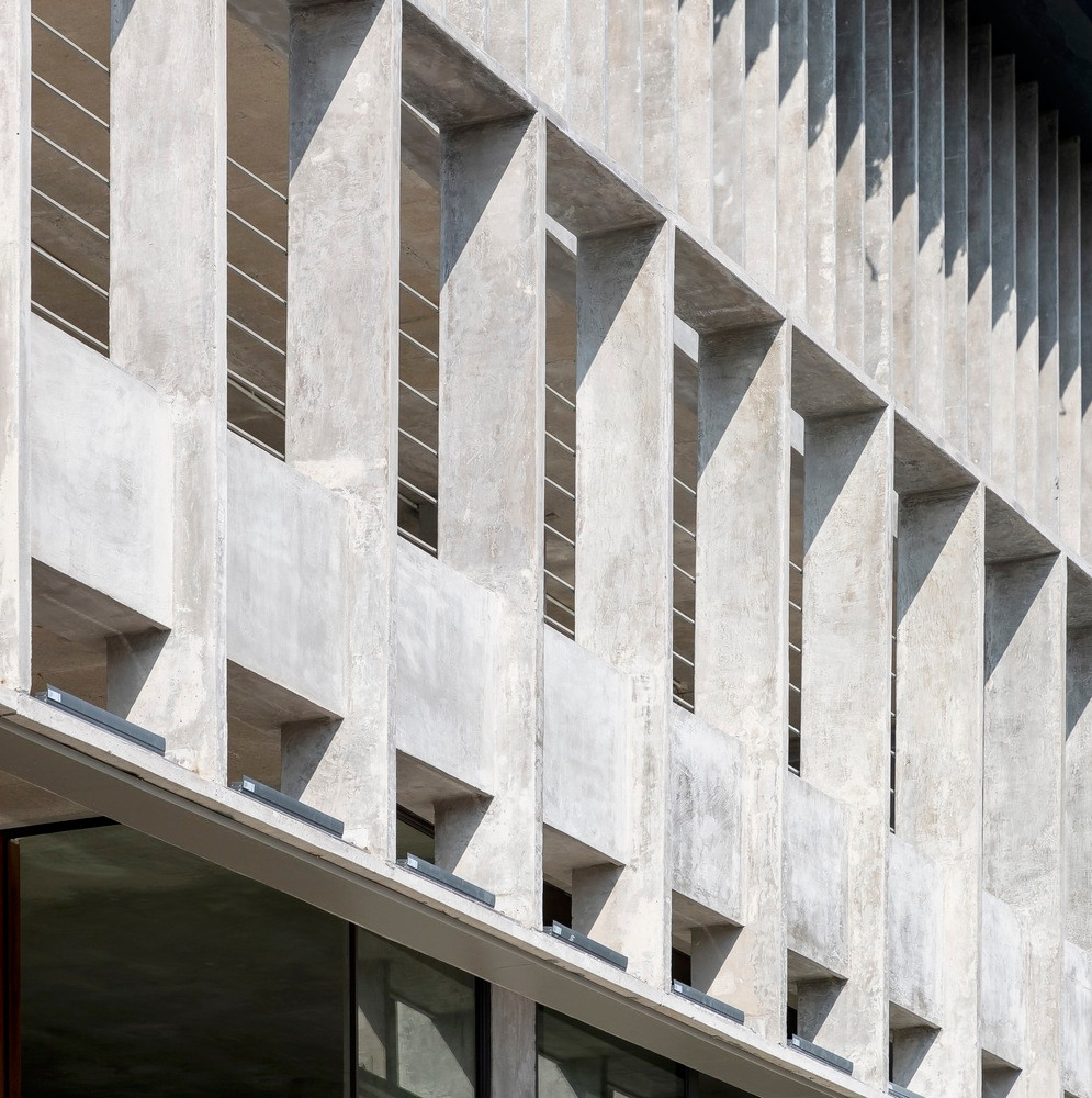 Bên ngoài là các tấm bê tông đục lỗ nhẹ có tác dụng giống như một chiếc kệ cứng bảo vệ bên trong khỏi môi trường tự nhiên khắc nghiệt.