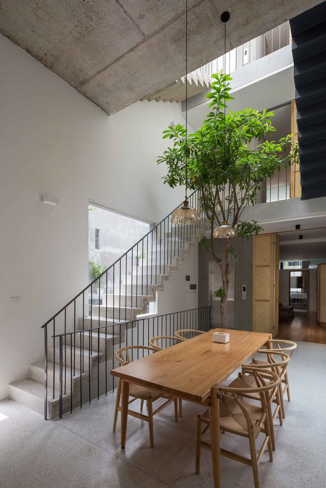 Ngôi nhà được chia thành hai khu vực: khu vực thương mại gồm hai tầng và khu vực sinh hoạt gia đình. Không gian sinh hoạt chung như phòng khách, thư viện, phòng ăn và bếp được bố trí ở các tầng khác nhau với chiều cao trần khác nhau tạo nên không gian mở liên tục. Ảnh: Hoang Le